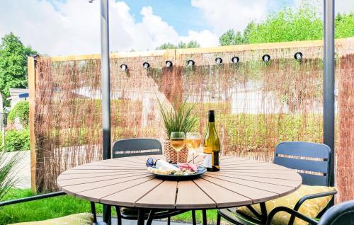 a table with two glasses of wine and a bowl of food at Knus chalet in het hart van Zeeland - VP028 in Heinkensand