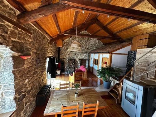 un salon avec une table et un mur en pierre dans l'établissement Maison de campagne atypique à Tence, à Tence