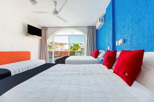 a hotel room with two beds and a window at Capital O Hotel El Mejicano, Acapulco in Acapulco