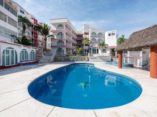 a swimming pool in front of a building at Capital O Hotel El Mejicano, Acapulco in Acapulco