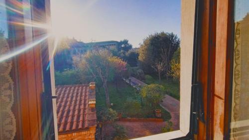 an open window with a view of a garden at MARIA HOLIDAY HOMES La Pineta di Sinalunga in Sinalunga