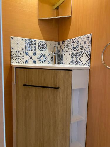 La salle de bains est pourvue d'un lavabo et d'une armoire revêtue de carrelage. dans l'établissement Camping Les Amandiers, à Castelnau-de-Guers