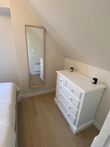 - une chambre avec une commode blanche et un miroir dans l'établissement Duplex appartment in a private greeny residence, à Tourgéville