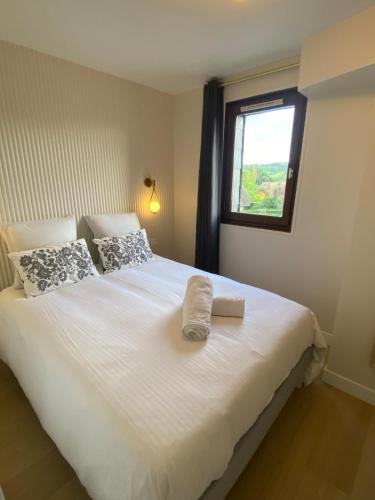 une chambre avec un grand lit blanc avec une fenêtre dans l'établissement Duplex appartment in a private greeny residence, à Tourgéville