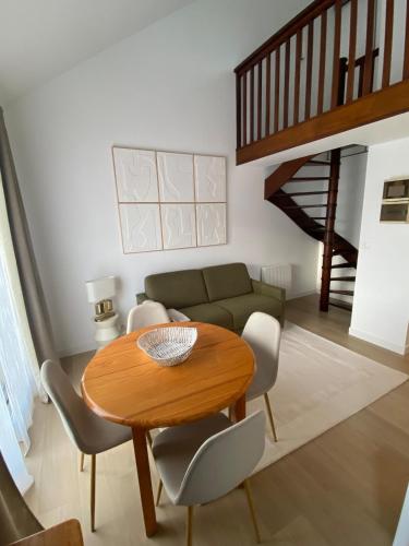un salon avec une table et un canapé dans l'établissement Duplex appartment in a private greeny residence, à Tourgéville