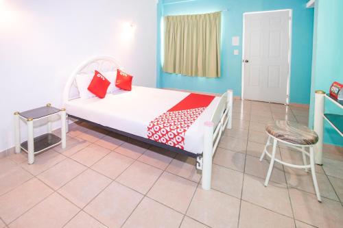 a bedroom with a white bed with red pillows at OYO Hotel Estacion,José Cardel,Parque Central Revolución in José Cardel