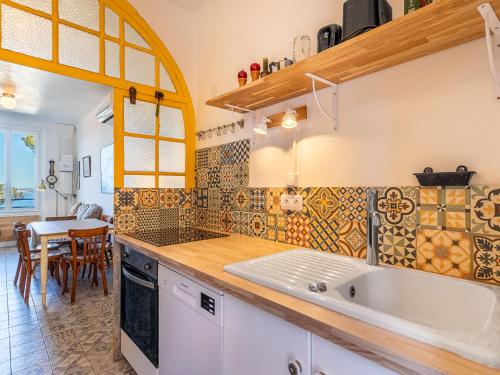 une cuisine avec un évier et une table avec des chaises dans l'établissement Villa Le Provençal by Interhome, au Pradet
