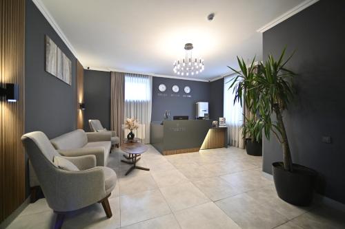 a living room with chairs and a table and a kitchen at Colette Hotel in Yerevan