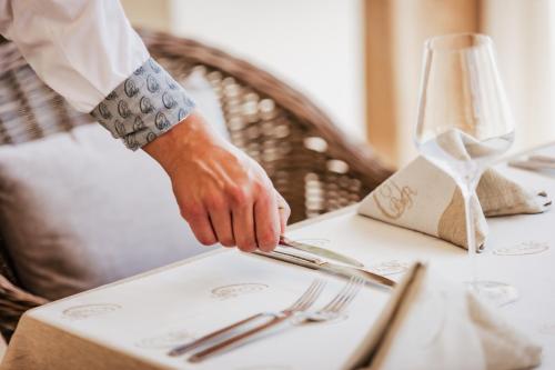 a person reaching for a fork and knife on a table at Onyx Beach Residence - Free Parking & Beach Access in Sveti Vlas