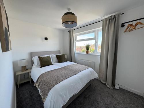 a bedroom with a large bed and a window at Modern & Spacious Home in Exeter - Smart TV & Xbox in Pinhoe