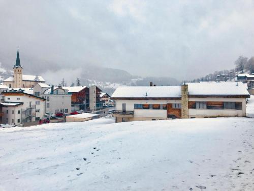 a town with snow covered buildings and a church at Apartment Fifinhaus by Interhome in Fiesch