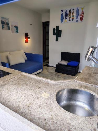 a bathroom with a sink and a couch in a room at CosteiraPRAIASOLPontaNegra, Natal-RN in Natal