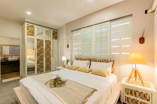 a bedroom with a large white bed and a bathroom at Hide & Seek River Villa in Ban Wang Wa (1)