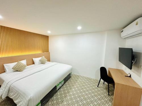 a hotel room with a large bed and a desk at The Cozy 77 in Bangkok