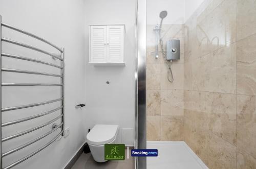 a white bathroom with a toilet and a shower at Two Bedroom Apartment By Arhouse Apartments Short Lets & Serviced Accommodation Shoreditch With Free WiFi in London