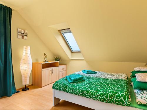 a bedroom with a green bed and a window at Villa Pool & Garden Villa by Interhome in Prague