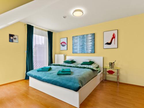 a bedroom with a large bed with blue sheets at Villa Pool & Garden Villa by Interhome in Prague