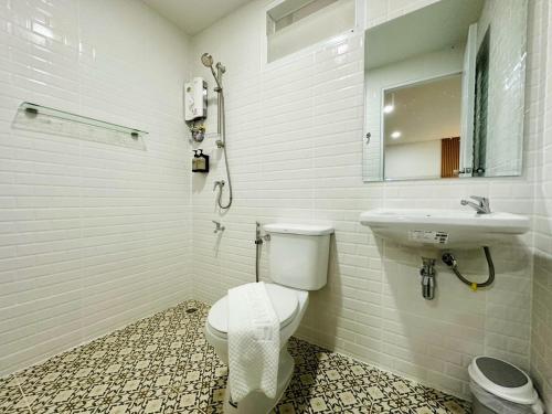 a bathroom with a toilet and a sink at The Cozy 77 in Bangkok