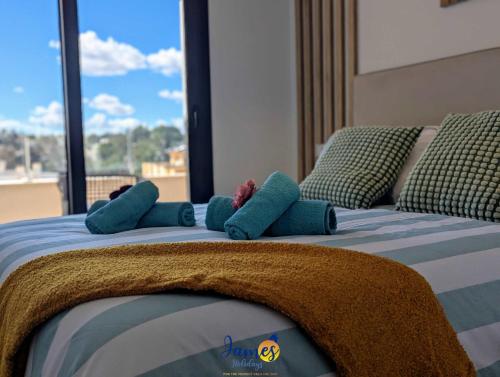 a bed with blue pillows on it with a window at Luxury penthouse with Solarium and Com Pool VM78 in Villamartin