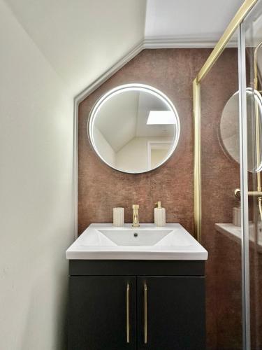 a bathroom with a sink and a mirror at Luxury Coastal Cottage in Portsoy