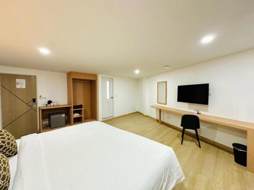 a hotel room with a bed and a flat screen tv at The Cozy 77 in Bangkok