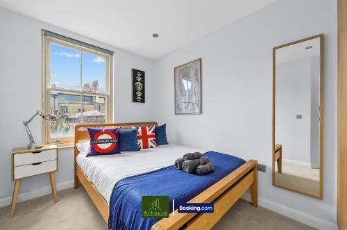 a bedroom with a bed with a teddy bear on it at Two Bedroom Apartment By Arhouse Apartments Short Lets & Serviced Accommodation Shoreditch With Free WiFi in London