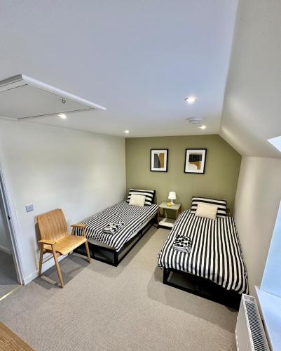 a room with two beds and a chair at Luxury Coastal Cottage in Portsoy