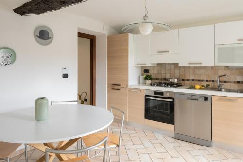 a kitchen with a white table and a table and chairs at Il nido di Cate in Fossano