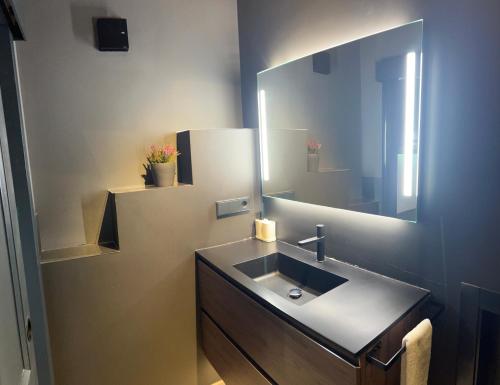 a bathroom with a sink and a mirror at One&Lux Gran Poder - Modern loft with Private Pool and Terrace in Seville