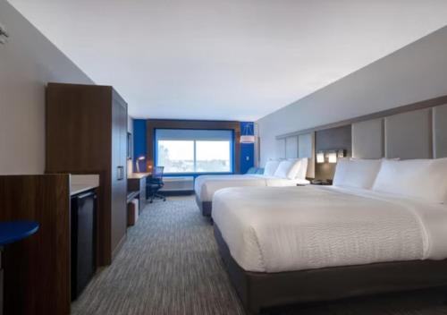 a hotel room with two beds and a window at Holiday Inn Express & Suites - Detroit - Dearborn by IHG in Dearborn