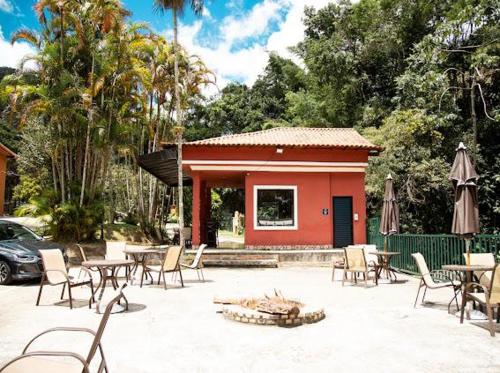 a patio with tables and chairs and a building at Apart-hotel Cantinho da Serra in Nova Friburgo