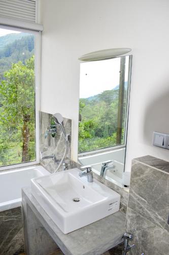 a bathroom with a sink and a large window at Flaming Tree Resorts in Kiriwan Eliya
