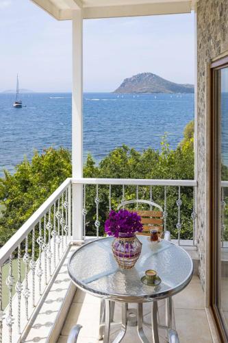 a table on a balcony with a view of the ocean at Elite Hotel Yalıkavak in Yalıkavak