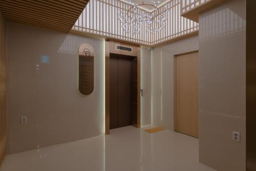 a hallway with a chandelier and a door in a building at Vibe Hotel Gimhae Jangyu in Gimhae