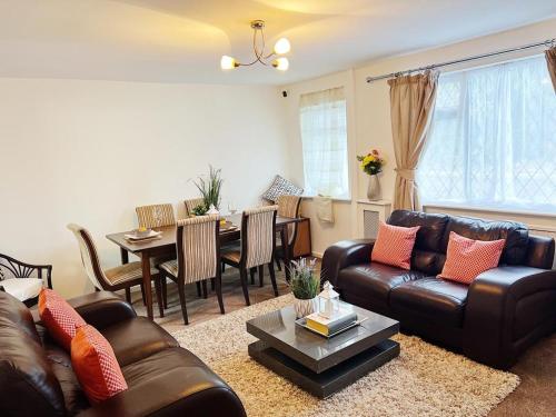 a living room with a leather couch and a table at Immaculate Haven in Westhoughton
