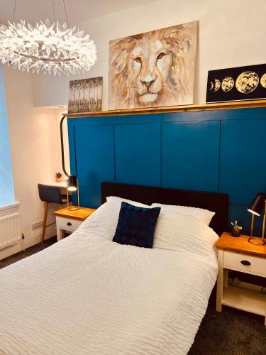 a bedroom with a bed with a blue head board at Central, Modern Apartment - Private Terrace - Dog Friendly in Aberdeen