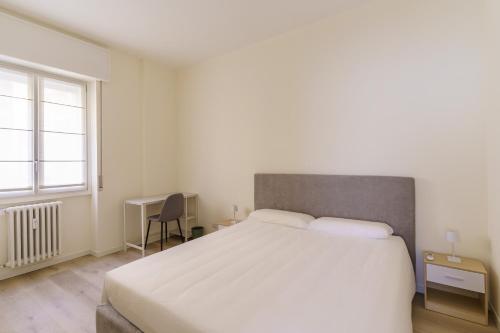 a bedroom with a large white bed and a window at Bergamo Hideout in Bergamo