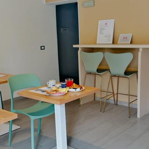 a table and chairs with a plate of food on it at Giardini B&B in Modena