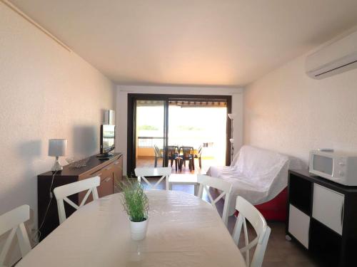 Cette chambre comprend une table, un lit et une cuisine. dans l'établissement Splendide 3 pièces climatisé avec 3 terrasses, proche mer, parking sécurisé - FR-1-307-135, au Grau-du-Roi