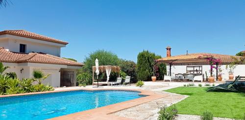 a backyard with a swimming pool and a house at B&B Villa Pinos Málaga in Alhaurín de la Torre