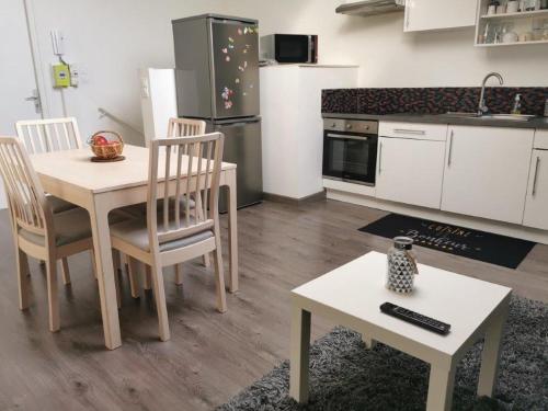 d'une cuisine avec une table, des chaises et une table. dans l'établissement Suite Condorcet 3 Ch 3 Sdb, à Reims