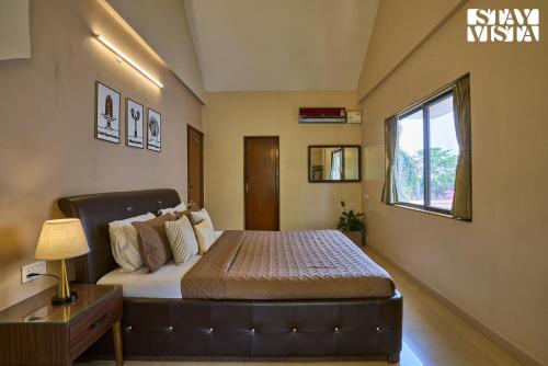 a bedroom with a bed and a window at StayVista at Solea with BBQ, Bonfire, AC in Panchgani