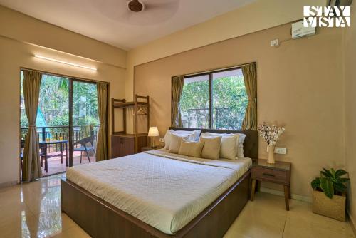 a bedroom with a large bed in a room with windows at StayVista at Solea with BBQ, Bonfire, AC in Panchgani