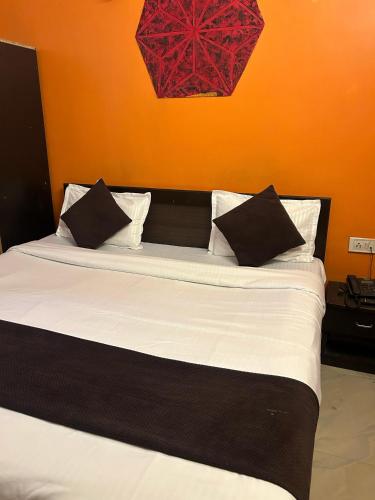 a bed with black and white pillows in a room at Hotel Decision in Akolia
