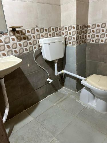 a bathroom with a toilet and a sink at Hotel Decision in Akolia