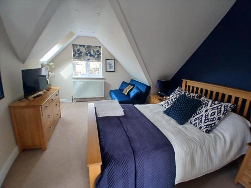 a bedroom with a large bed and a blue wall at The Herons in Goldsborough