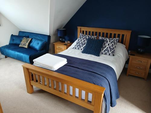 a bedroom with a bed and a blue wall at The Herons in Goldsborough