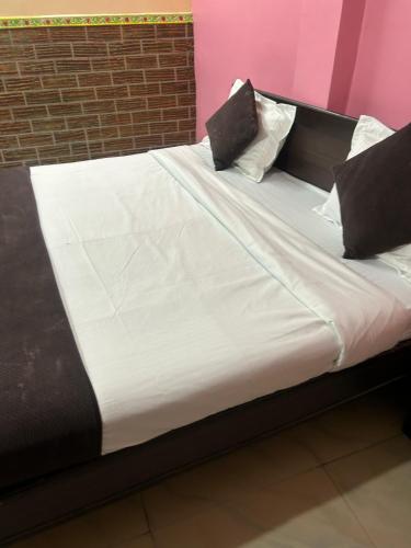 a bed with white sheets and pillows on it at Hotel Decision in Akolia