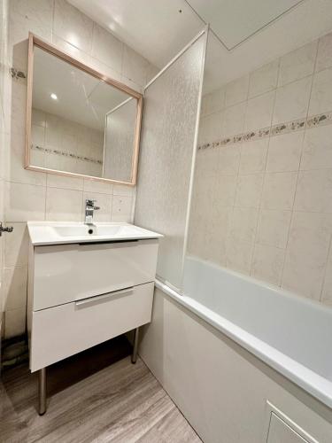 une salle de bain avec un lavabo, une baignoire et un miroir dans l'établissement Le Repère - 2 à 4 personnes - Lit King Size - Proche Gare, à Nancy