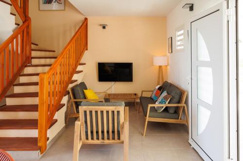a living room with a staircase and a tv at Villa Boréale in Capesterre-de-Marie-Galante
